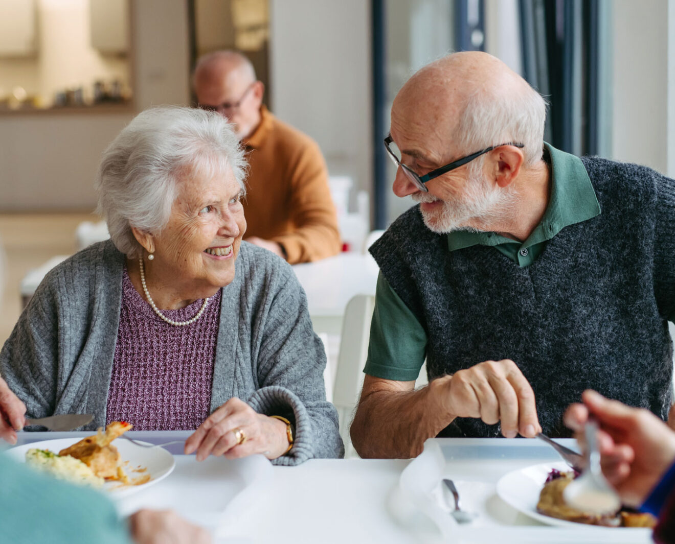 Deux personnes âgés qui mangent dans le réfectoire d'une maison de retraite